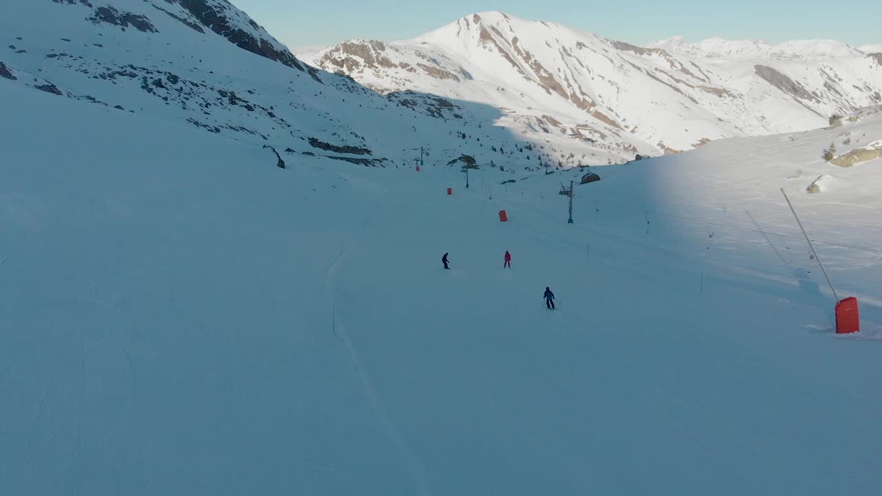 无人机/航拍视频滑雪和滑雪板在一个晴朗的一天在阿尔卑斯山，欧洲。视频素材