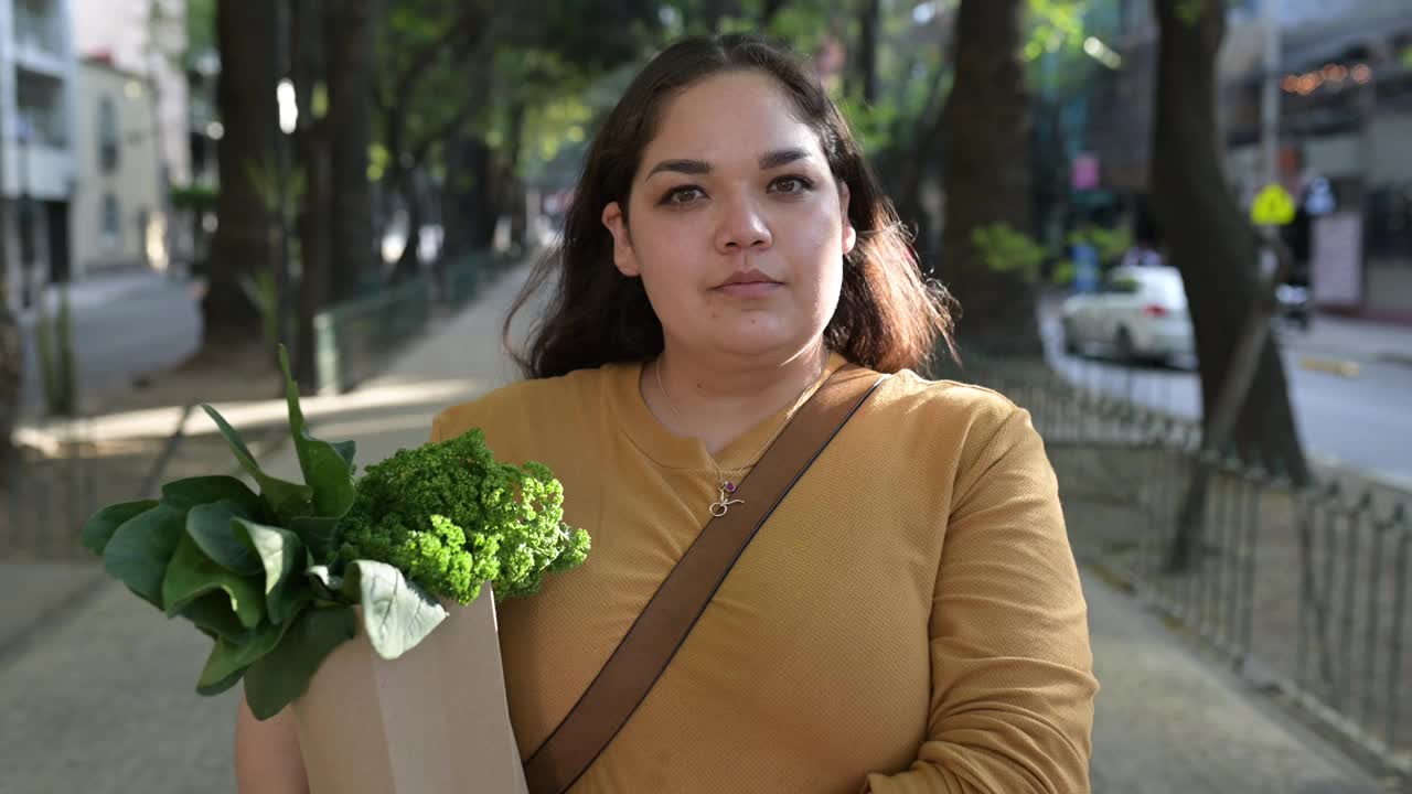 拉丁妇女的肖像，拿着装满蔬菜的可重复使用的袋子视频素材