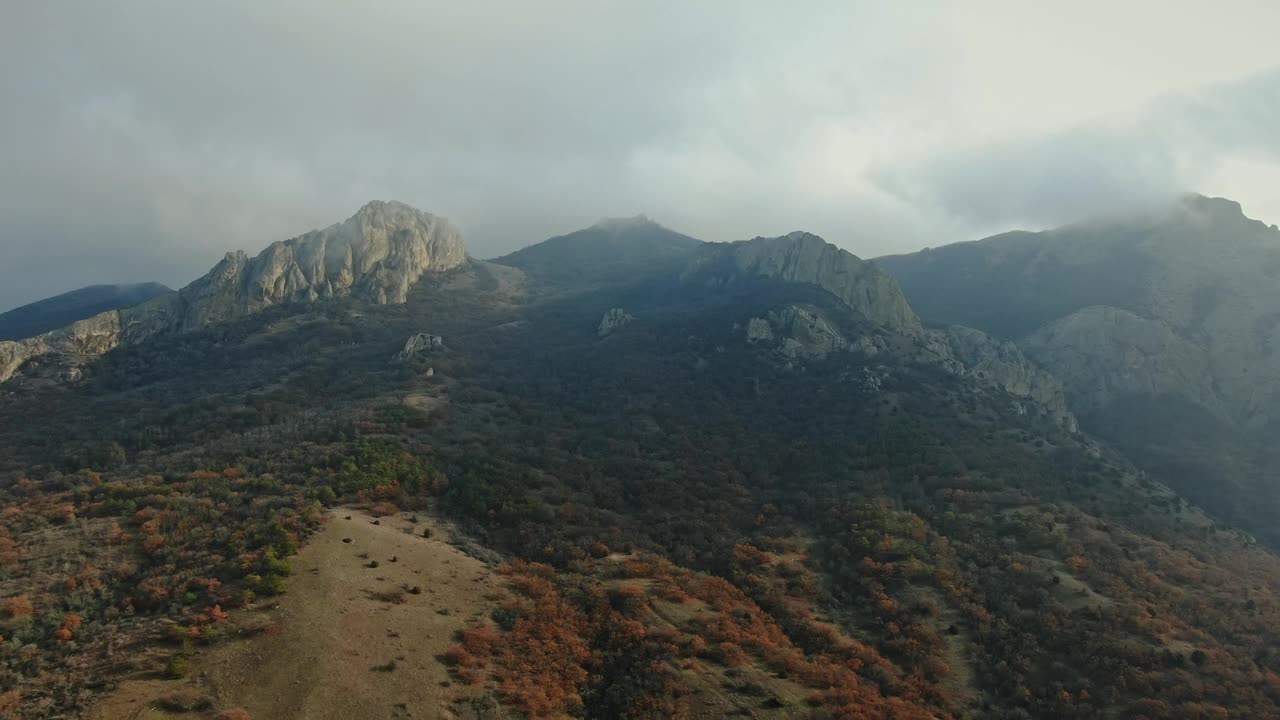 鸟瞰图。飞到山顶，上面有云。秋天。主要是多云的。视频素材