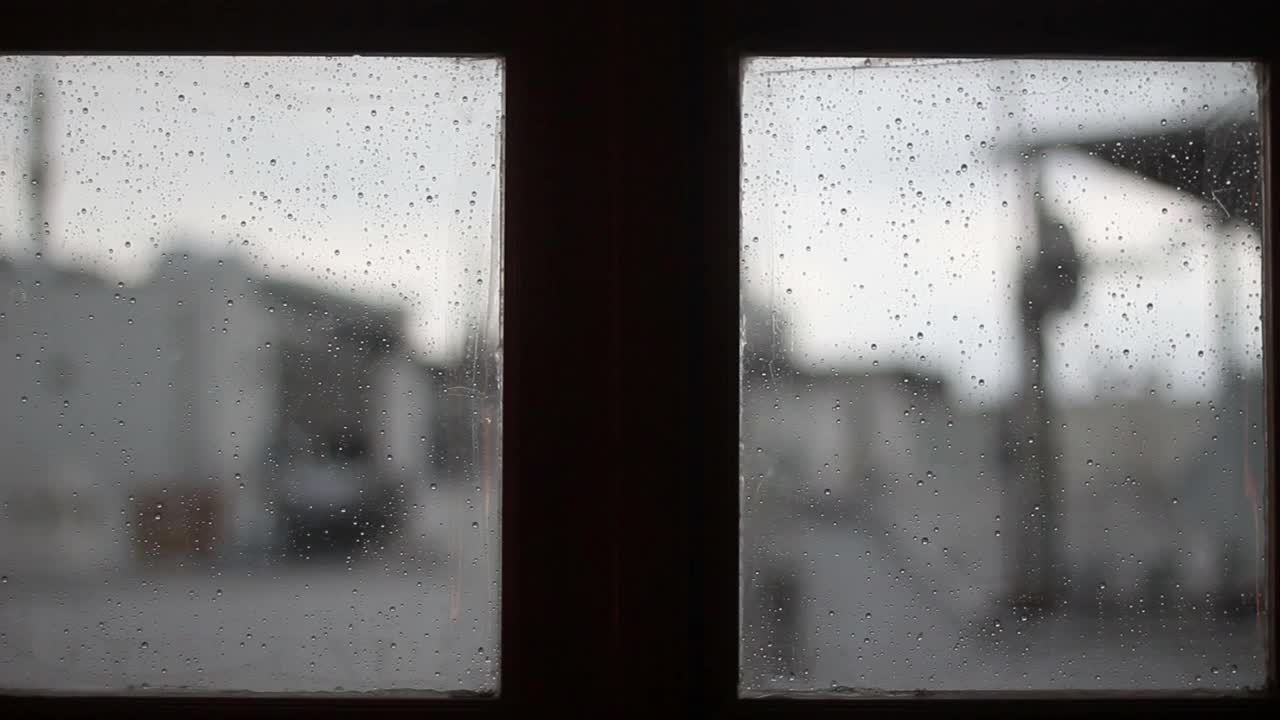 特写雨落在玻璃在前面的汽车，水滴在玻璃上视频素材