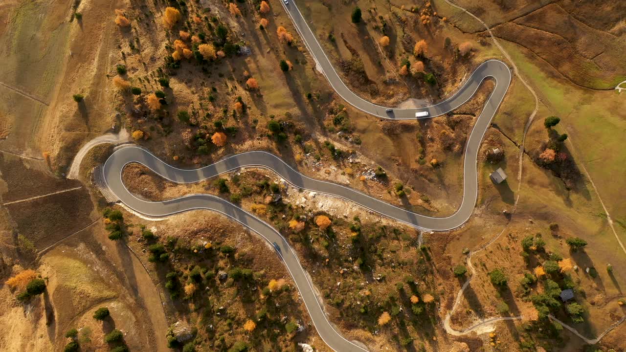 道路和汽车之间的秋天森林-航拍镜头视频下载