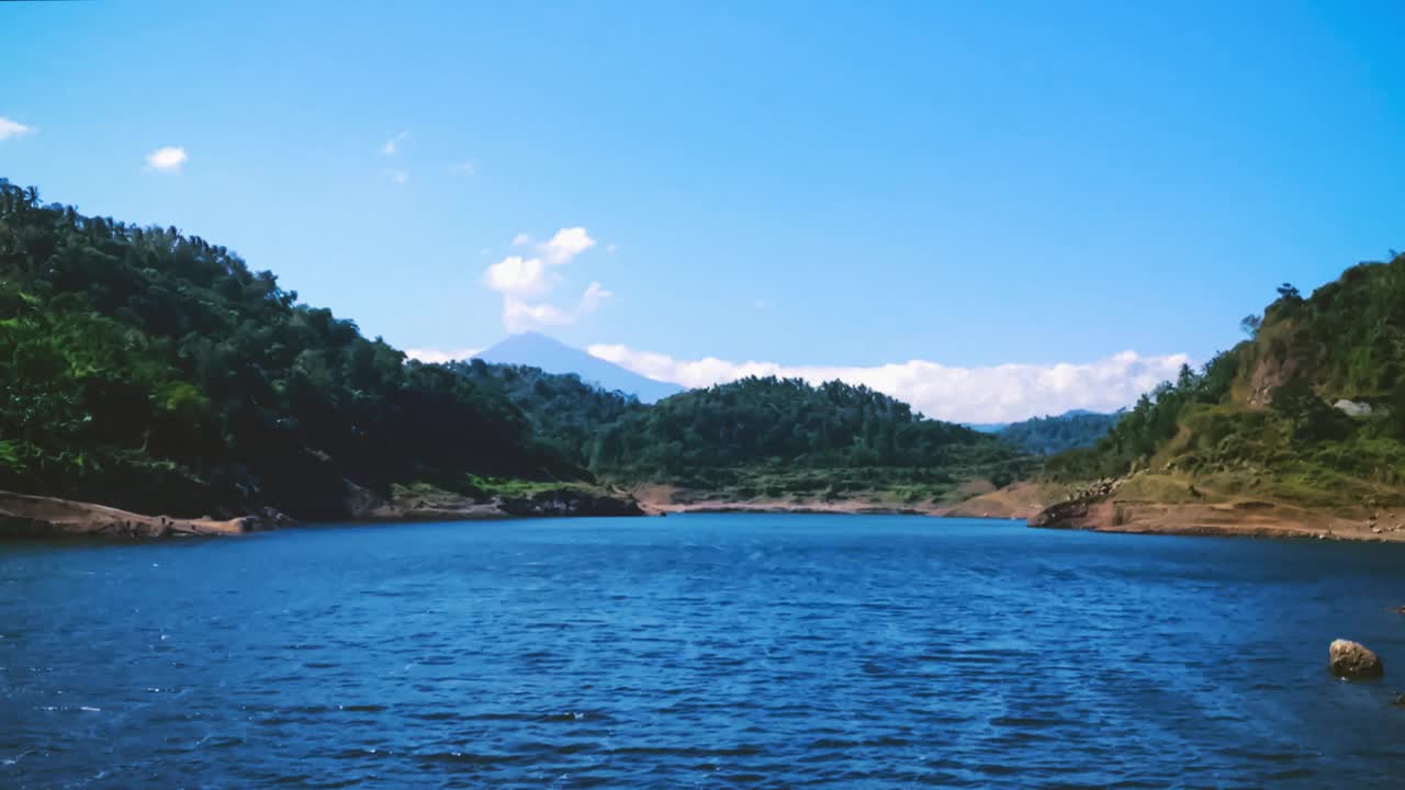 在一个阳光明媚的日子，Titab Ularan，在巴厘岛之间的山之间最大的大坝的湖水涟漪的观点视频素材