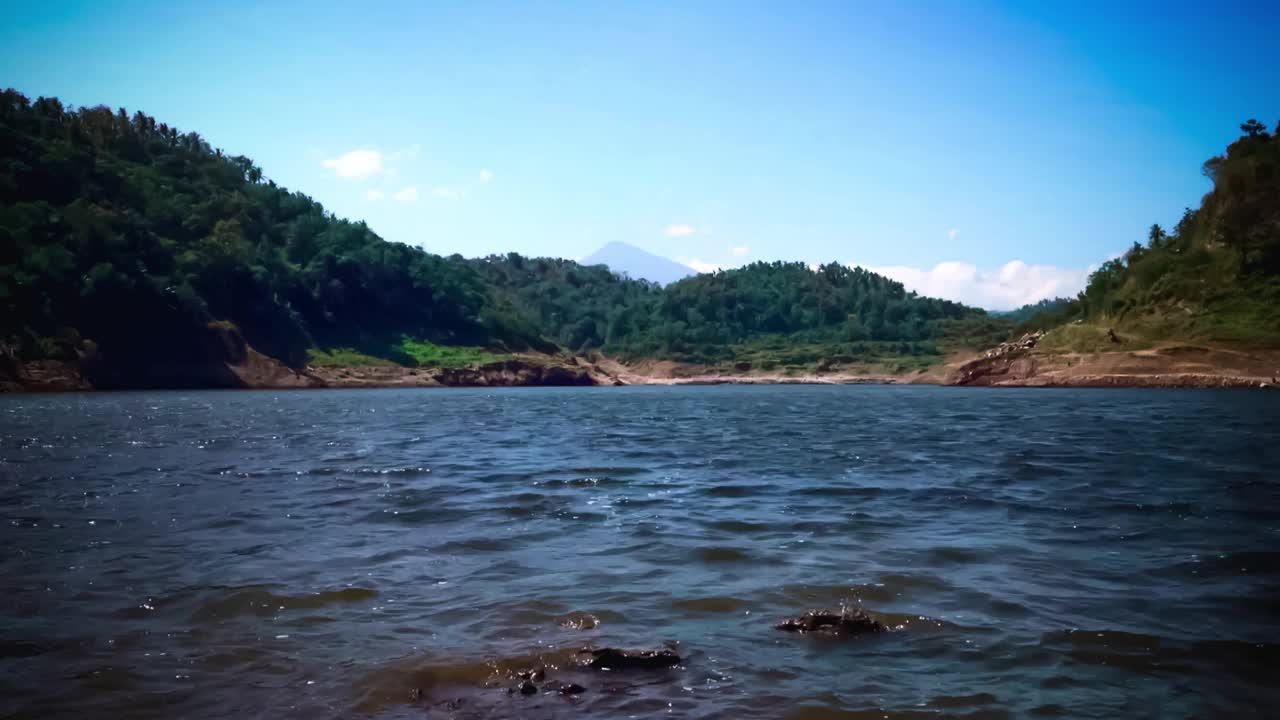 在巴厘岛最大的大坝在干燥季节，Titab Ularan之间的山之间的湖水涟漪的时间流逝视频素材