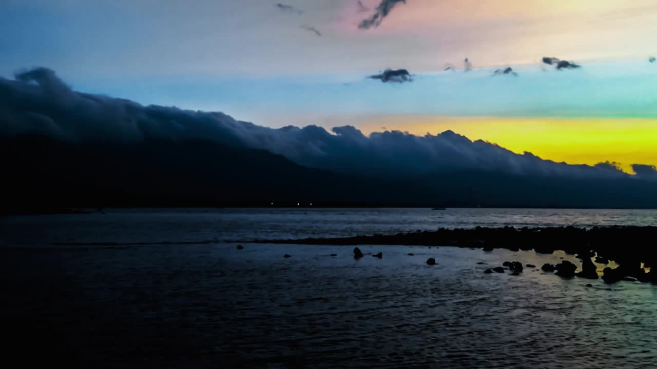 乡村热带岩石海滩景色与日落在天空和平静的海水涟漪在Umeanyar村视频素材