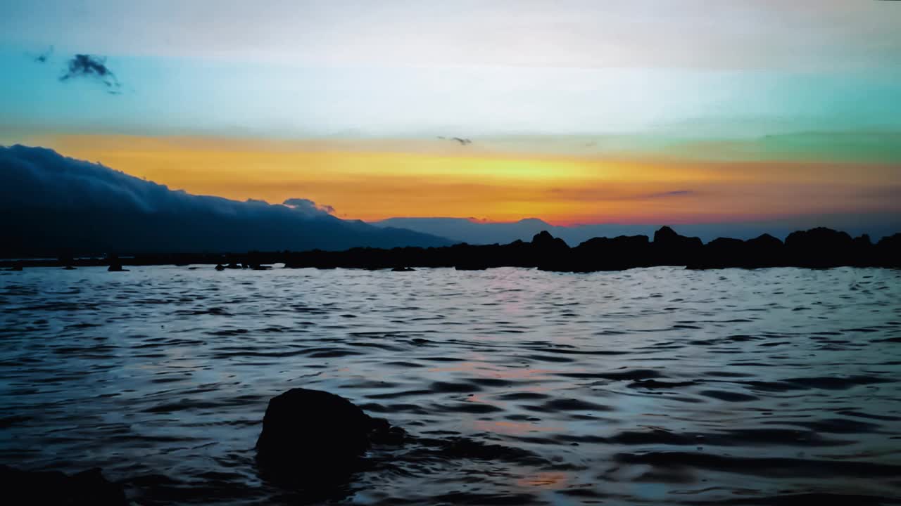 在Umeanyar村热带岩石海滩上的傍晚阳光与平静的海浪视频素材