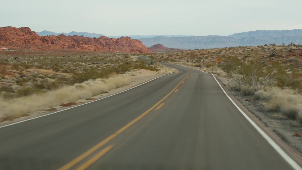 公路旅行，在火谷驾驶汽车，拉斯维加斯，内华达州，美国。在美国搭便车旅行，高速公路旅行。红色外星岩石的形成，莫哈韦沙漠荒野看起来像火星。从汽车视频素材