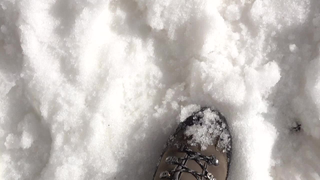 男人靴子在雪地上行走的特写视频素材