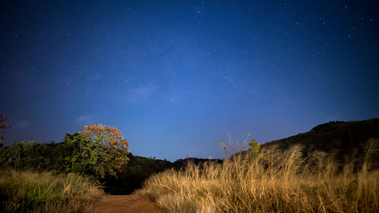 美丽的银河在天然的交通道路，草原和探险森林的山，晨曦前的星空视频素材