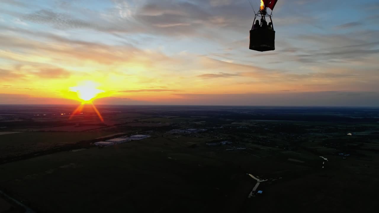 人们乘热气球旅行。美丽的红色心形气球在橙色夕阳的映衬下在天空中飞翔。视频素材