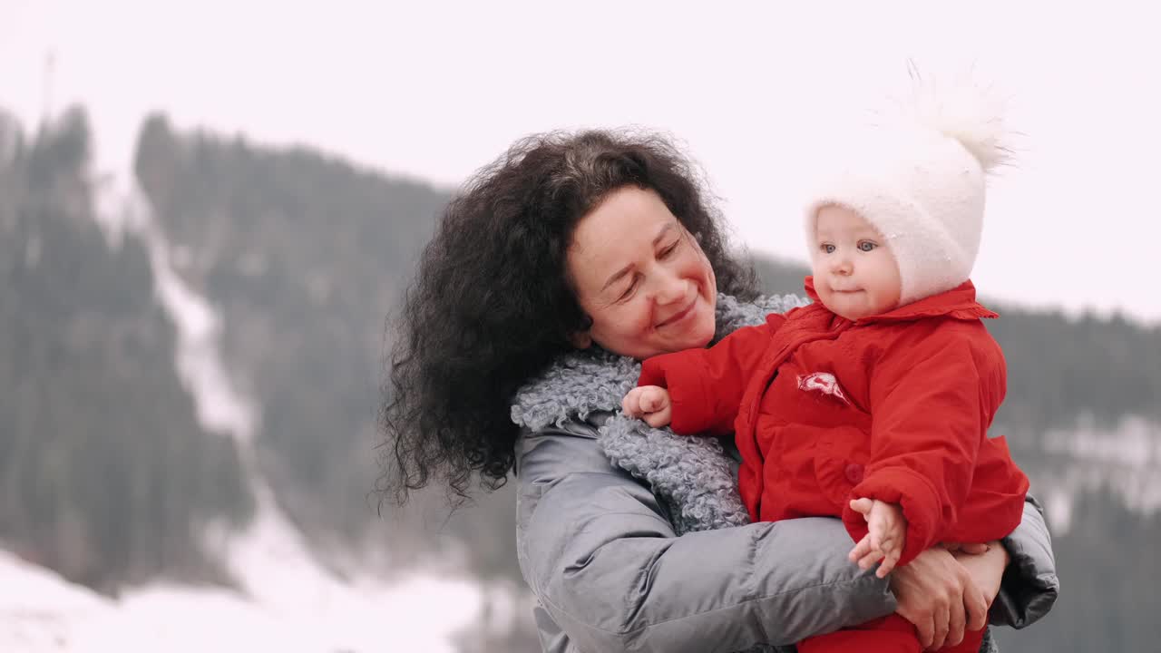 快乐的奶奶在冬天的山上抱着孙子视频素材