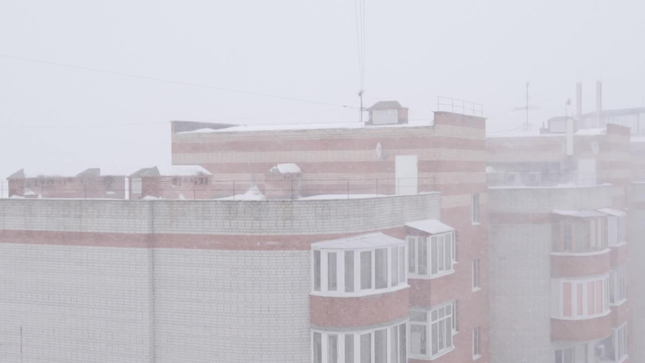 大雪在城市中，映衬着住宅楼。冬天。缓慢的莫视频素材