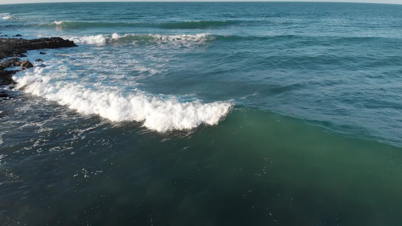 在阳光明媚的冬日，海面拍浪的鸟瞰图。海水表面纹理，流动的波浪和自然的概念和旅游视频素材