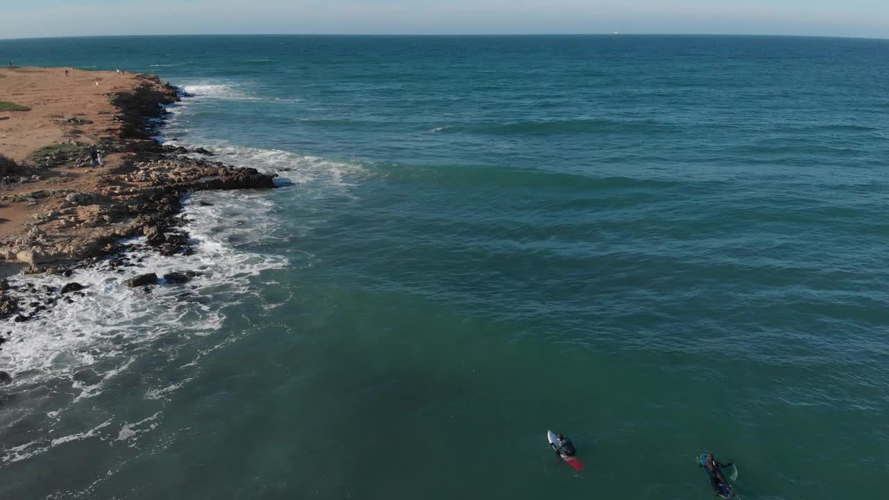 在阳光明媚的日子里，海浪拍向岩石海滩的海面鸟瞰图。海水表面纹理，波浪流动。自然和旅游的概念视频素材