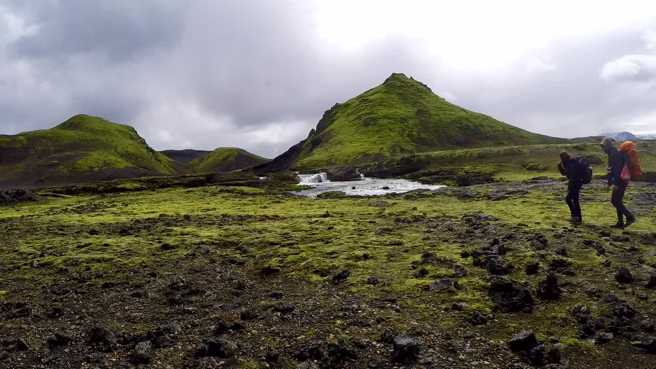 两个年轻人从冰岛的Landmannalaugar徒步走过54公里的山谷视频素材