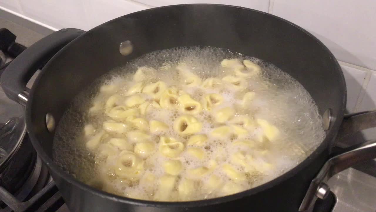 意大利饺子在烹饪锅中用水煮开的意大利饺子视频素材