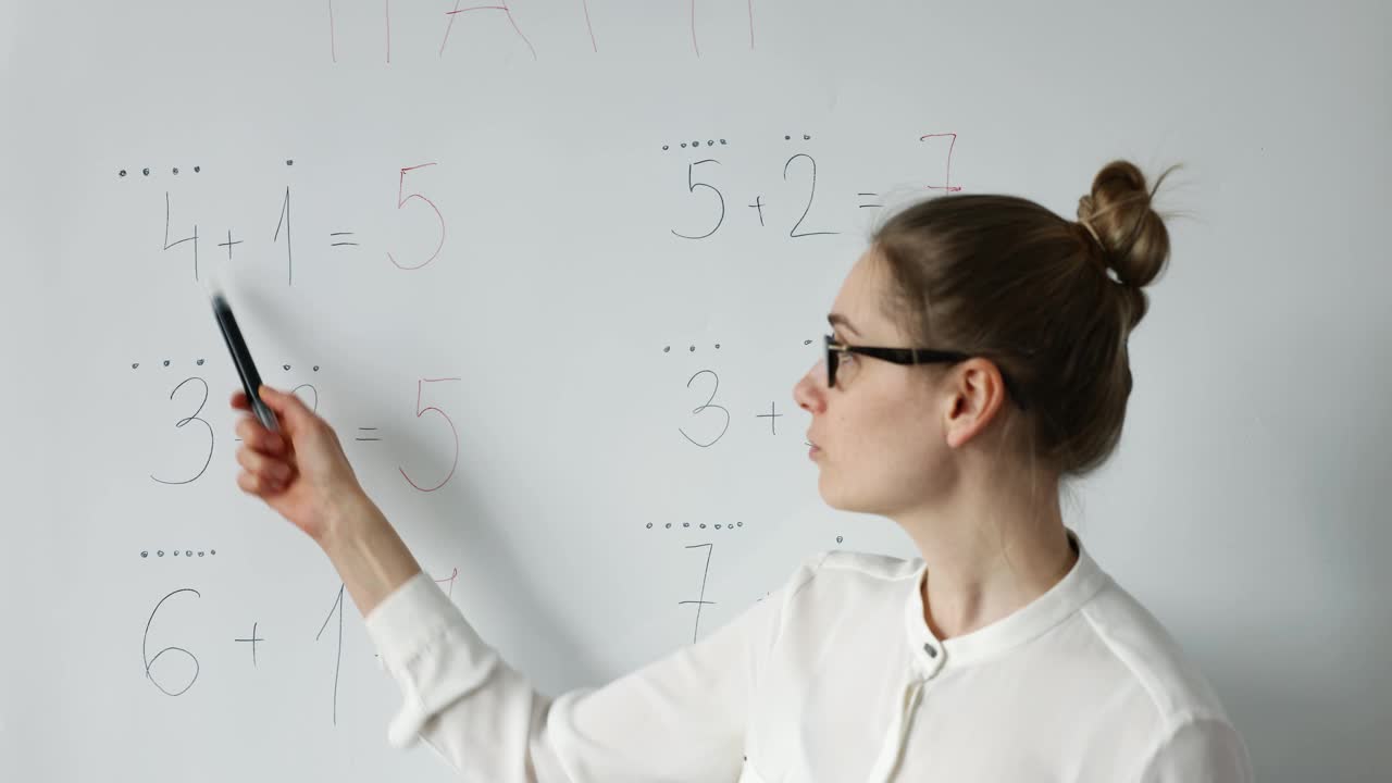 数学老师在教室的白板上讲解小学基础数学视频素材