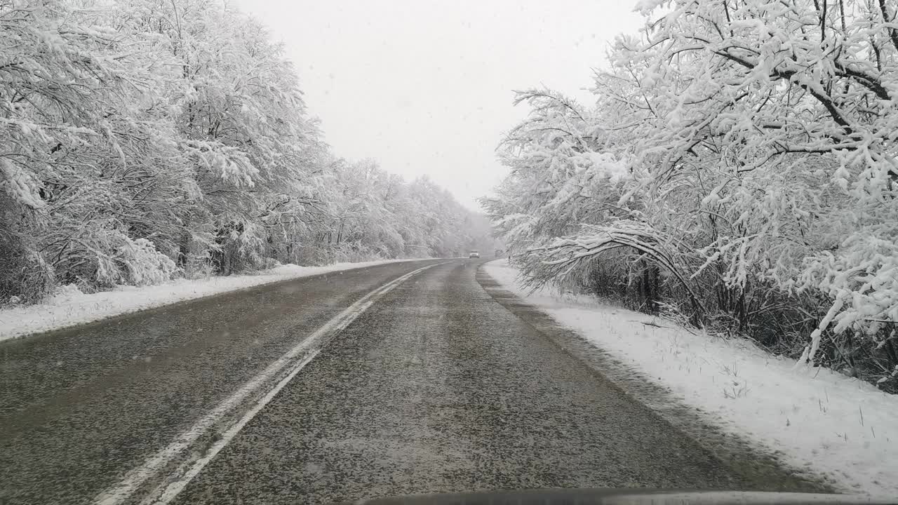 汽车观点。2019冠状病毒病(COVID-19)大流行期间，在大雪中行驶在高速公路上上班。生活忙碌，交通慢了下来。视频素材