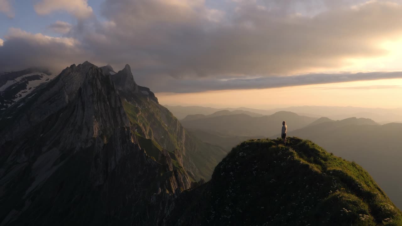 男徒步者从远处眺望令人惊叹的山景视频素材