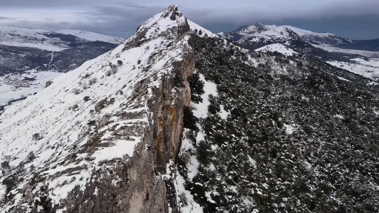 在白雪覆盖的山的悬崖上史诗般的飞行。高质量4k镜头视频素材