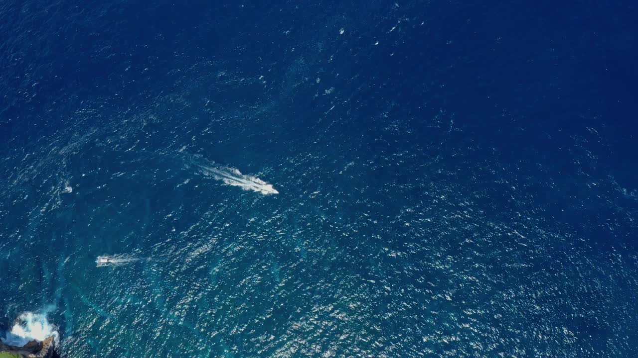 鸟瞰快艇在碧绿平静的海浪中航行视频素材