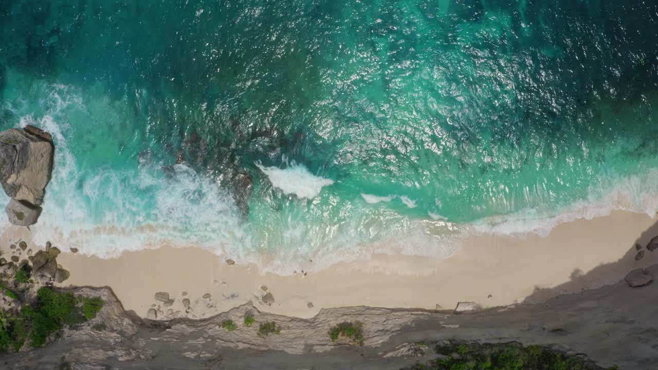 鸟瞰清澈的绿松石海浪拍打沙滩视频素材