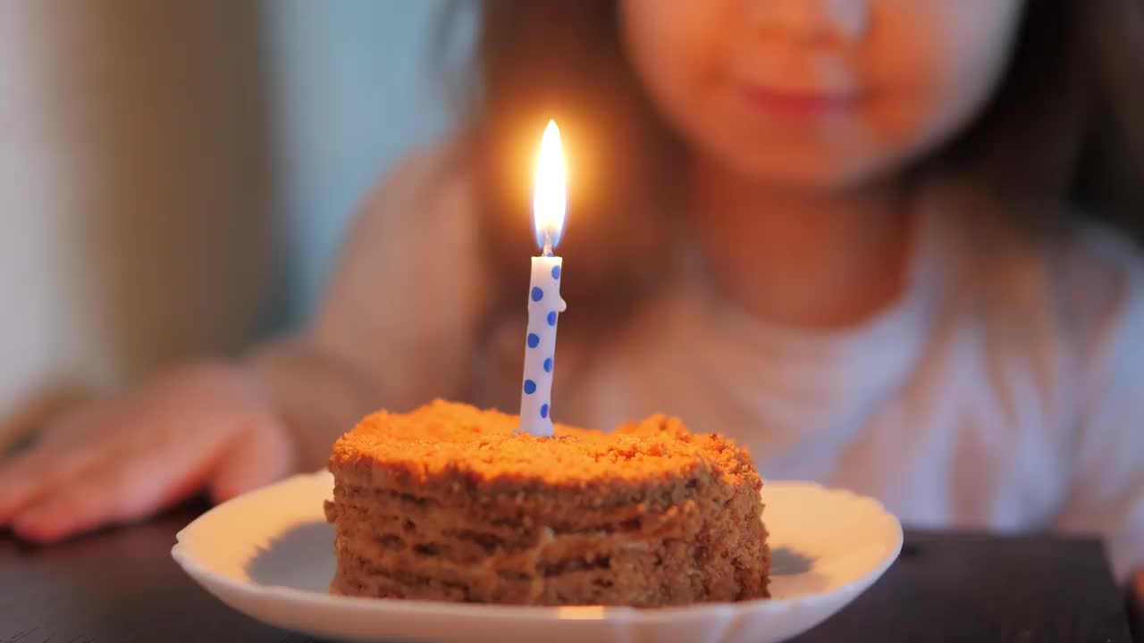 可爱的小女孩吹灭生日蛋糕上的蜡烛视频素材