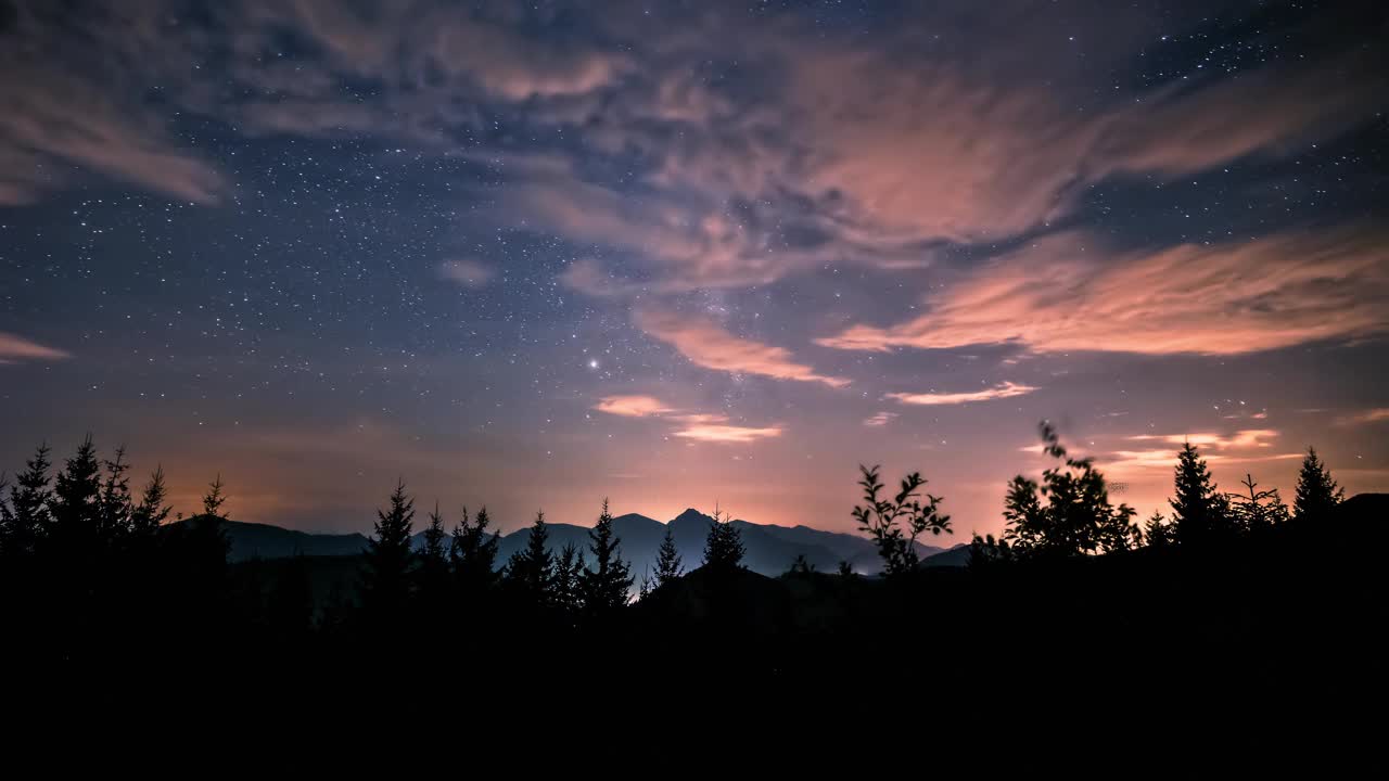 天文夜晚与银河系星星和云彩天空在森林山区景观时光流逝美丽的自然视频素材