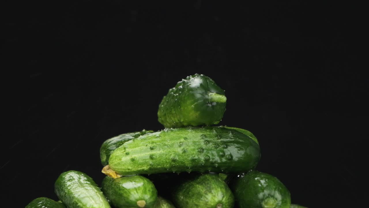 缓慢的运动。雨滴落在一堆旋转的绿黄瓜上。视频素材