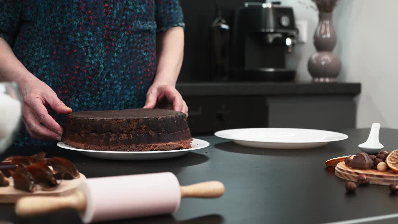 女性正在家庭厨房里制作传统的巧克力饼干蛋糕。女人在家里做饭，为家人准备香甜的糕点。制作馅饼的过程视频素材