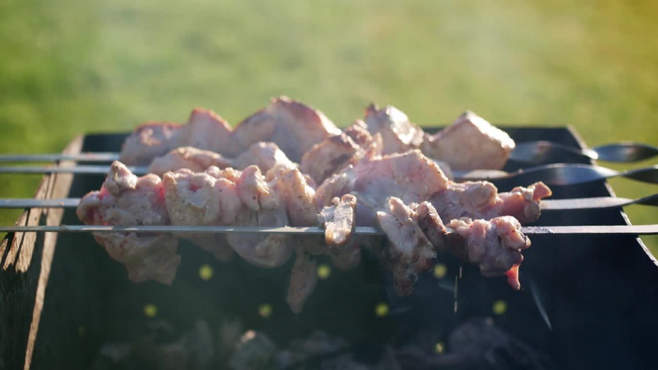 很多新鲜的肉串在坚硬的木炭烤架上烤，然后翻过来烤。视频素材