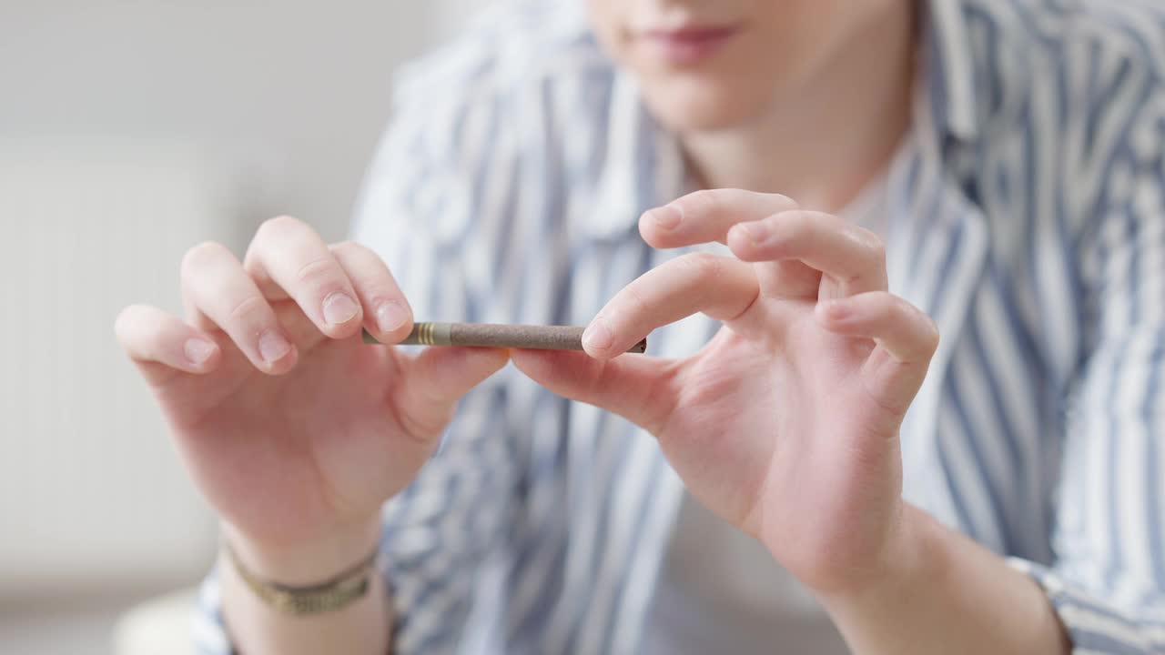 男性手折断雪茄的特写。一个陌生的年轻白种人正在戒烟。烟草问题和保健。视频素材