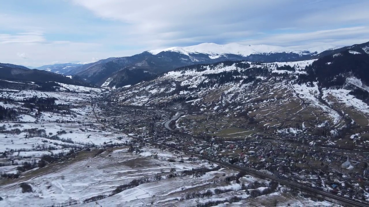 从无人机到冰雪覆盖的喀尔巴阡山脉和村庄的景观。视频素材