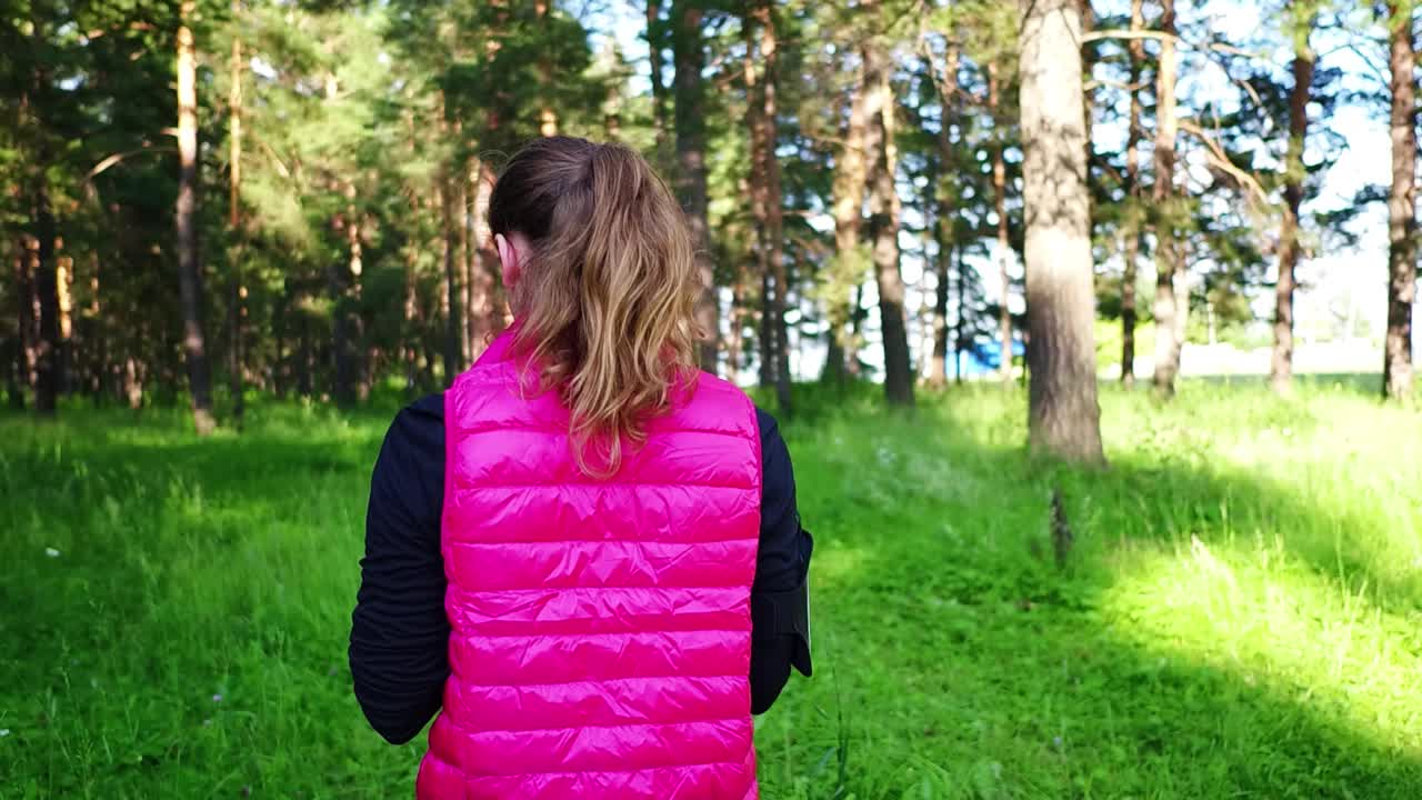 美丽的女孩穿着运动服，在春天的山林里奔跑视频素材