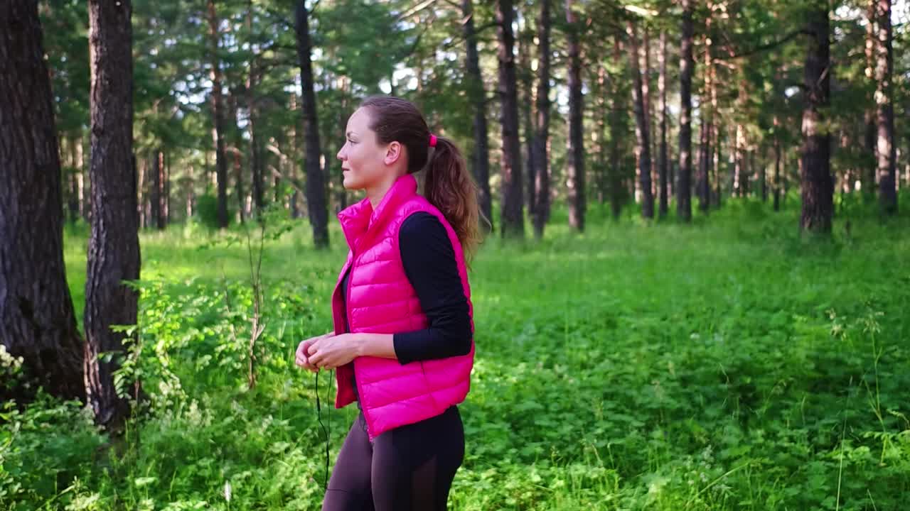 美丽的女孩穿着运动服，在春天的山林里奔跑视频素材