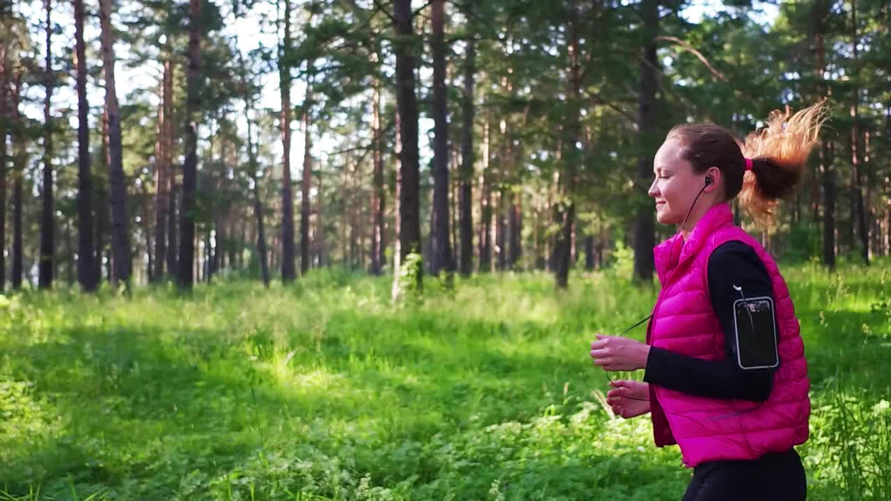 美丽的女孩穿着运动服，在春天的山林里奔跑视频素材