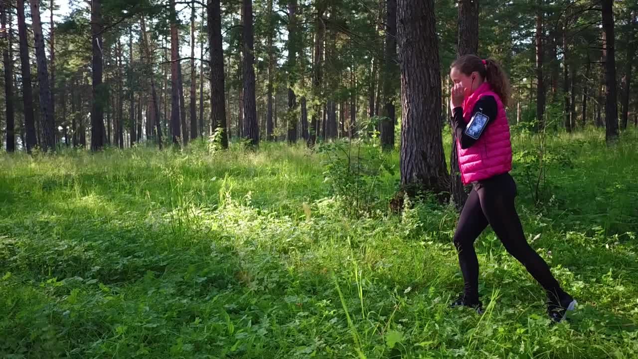 美丽的女孩穿着运动服，在春天的山林里奔跑视频素材