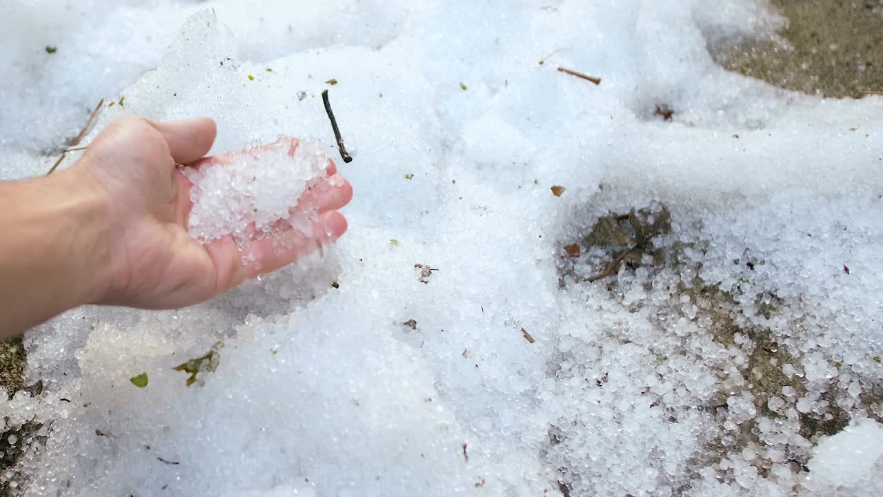 一场不寻常的冰暴后，人们触摸冰雹晶体堆，气候变化视频素材