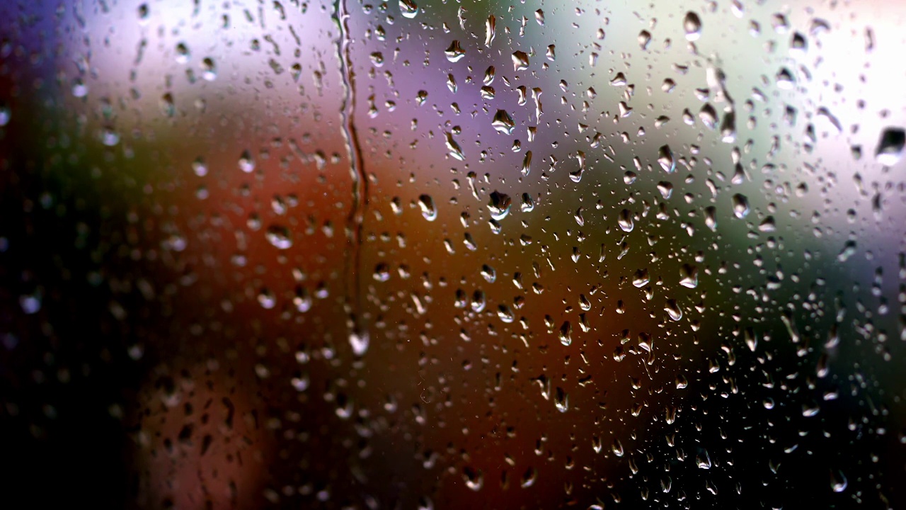 水滴的背景。雨季的雨落在玻璃窗上。大雨滴打在窗框上。特写镜头。视频素材