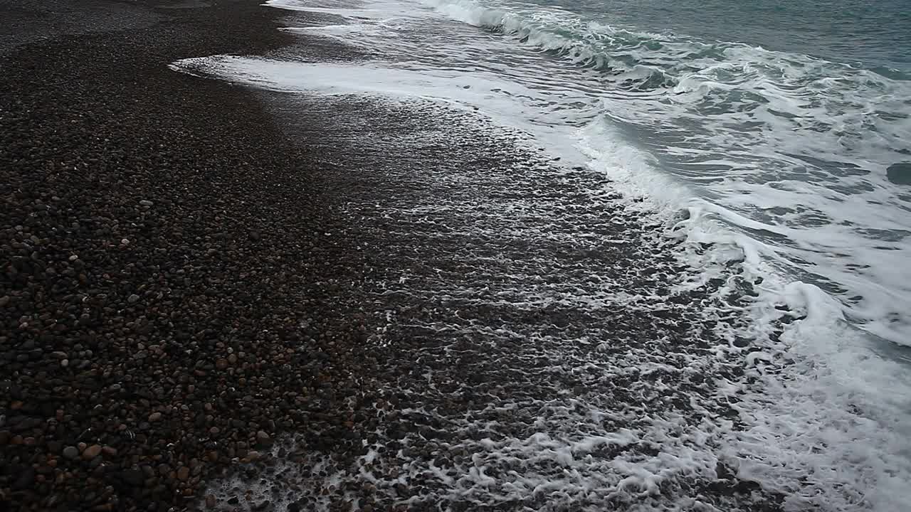 海浪，海浪在一个阴天的石头海岸，侧视图。视频素材