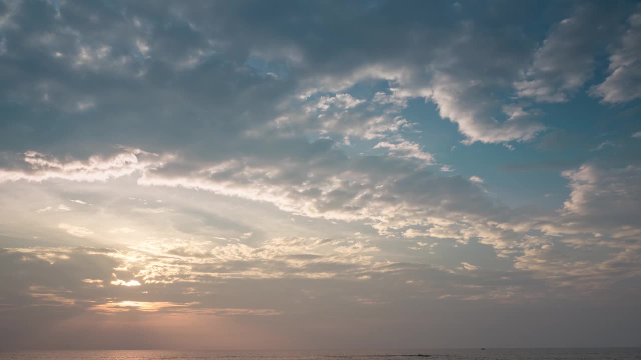 时间推移镜头日落天空的云彩在海上，彩色的自然阳光在天空黄昏。热带国家在炎热的天气和夏季大气中有害的臭氧层。视频素材