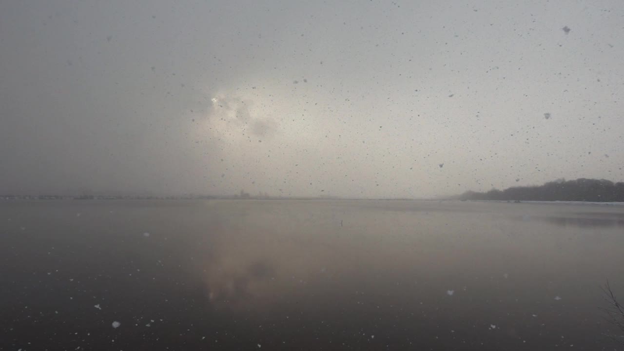 冬季的河流与平滑的水面和雪花在一个缓慢的运动视频素材