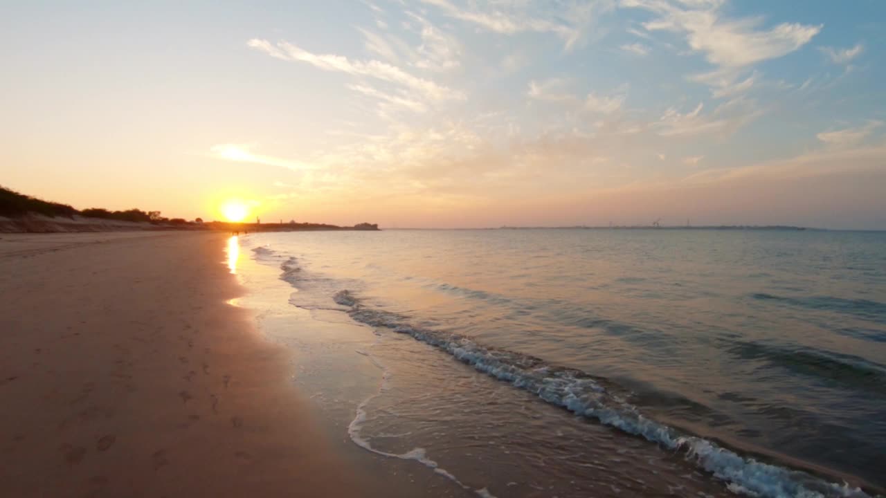 印度古吉拉特邦Bet Dwarka海滩日落的景色。夏日海滩背景。海滩上行人的剪影。旅游和假日概念，暑假放松视频素材