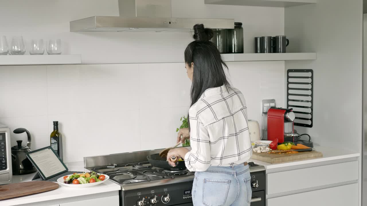 混血妇女烹饪食物在网上阅读食谱视频素材