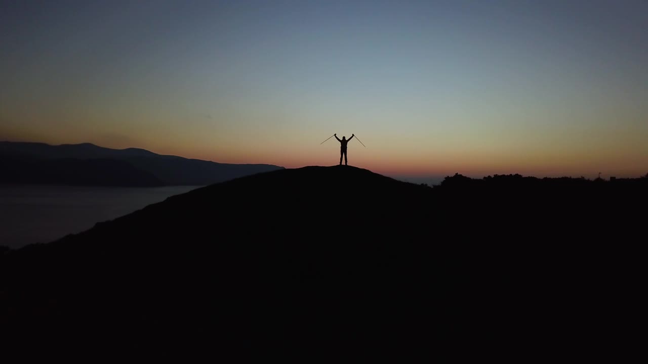 在斯诺登尼亚日出庆祝的徒步旅行者的空中剪影视频素材