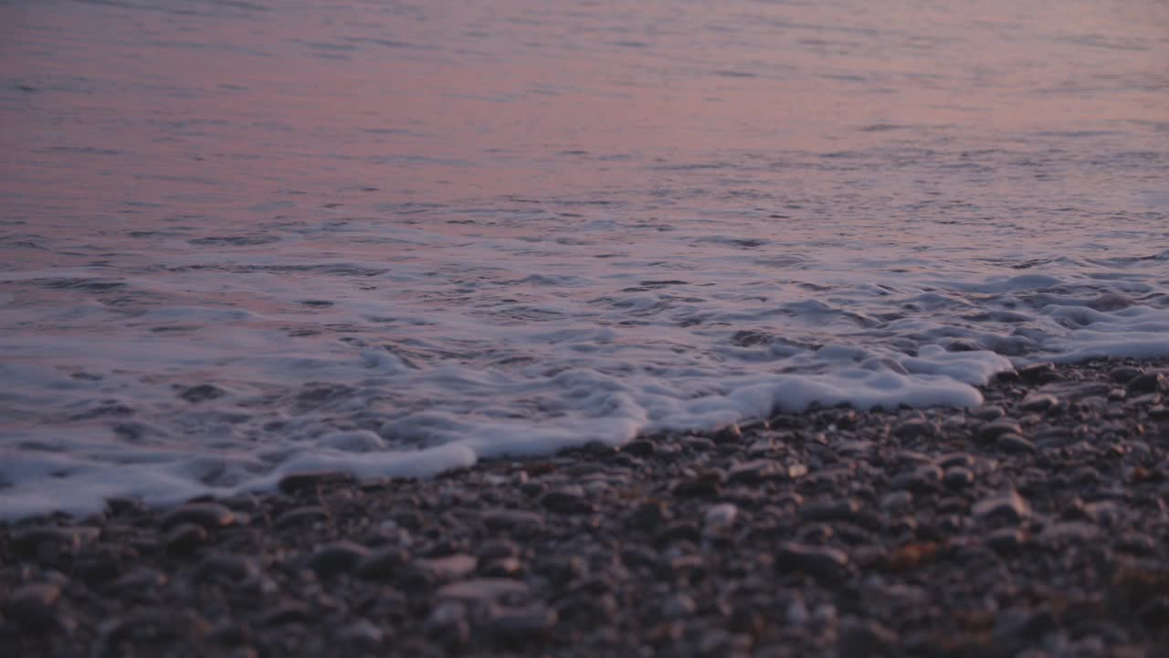 在黄昏时海浪撞击岩石海岸的特写镜头视频素材