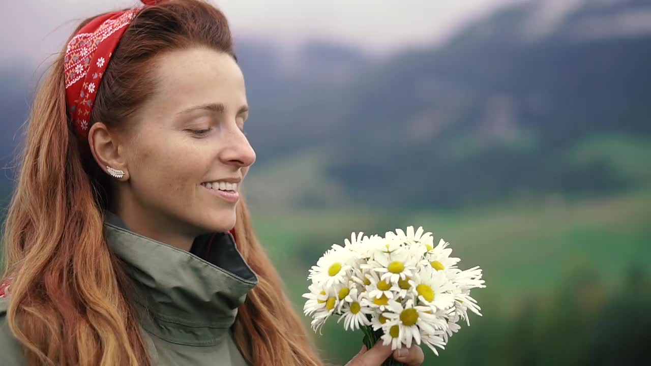 洋甘菊。一个女人在闻一束雏菊。视频素材