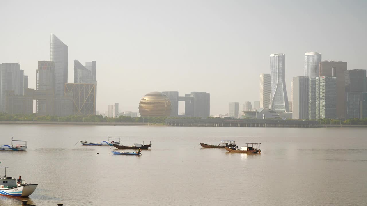 阳光明媚的一天，杭州市区著名的现代建筑，滨江海湾的船只，慢镜头全景4k中国视频素材