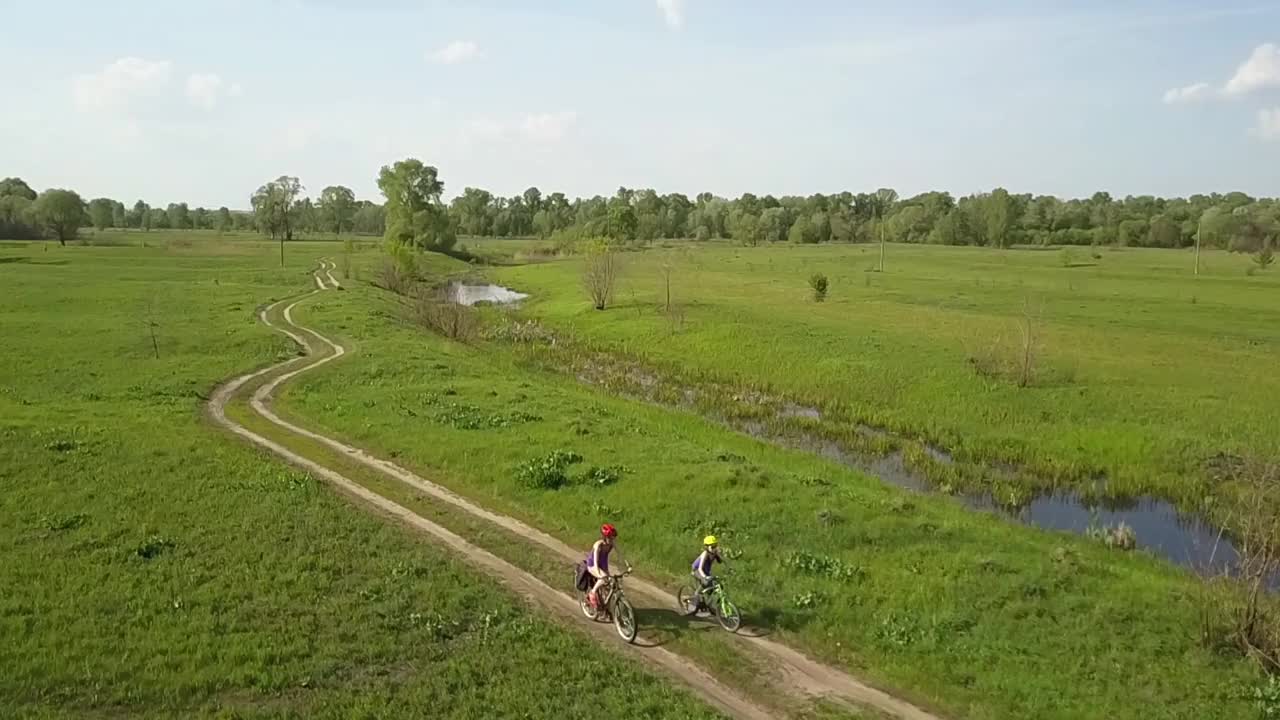 家庭在户外骑自行车鸟瞰，快乐活跃的妈妈和孩子玩得开心，家庭运动和健身视频下载