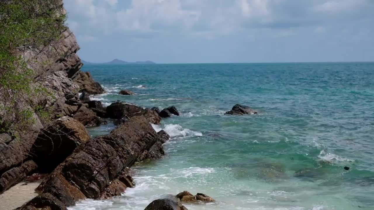 海浪撞击热带海滩岩石的慢动作视频素材