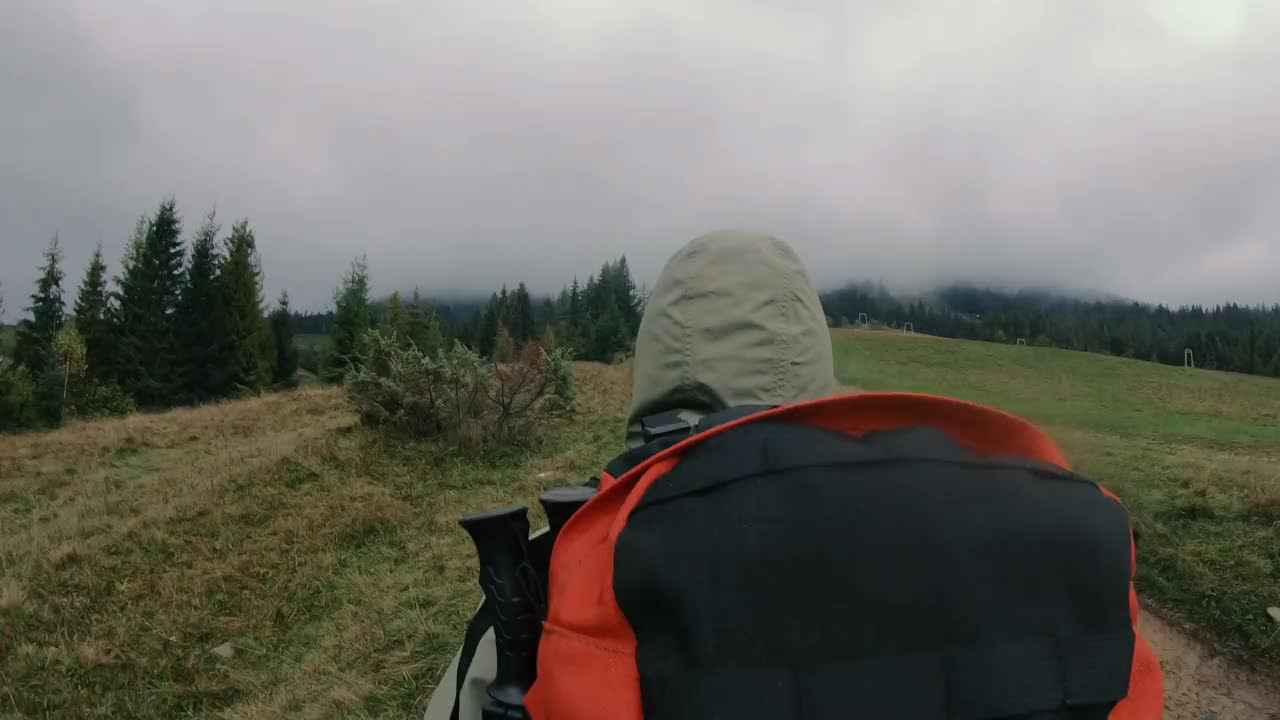 徒步旅行。一个背着旅游背包的女人在恶劣的天气里行走。视频素材